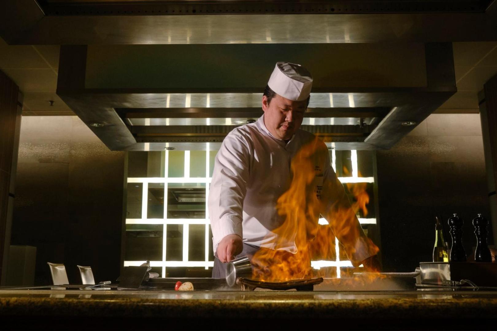Hotel Okura Amsterdam - The Leading Hotels Of The World Екстер'єр фото A chef cooking with a flaming wok